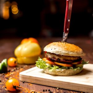 side-view-chicken-burger-with-lettuce-leaf-tomato-chicken-patty-burger-buns-black-pepper-table (1)